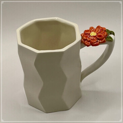 biały porcelanowy kubek z kwiatkiem czerownym